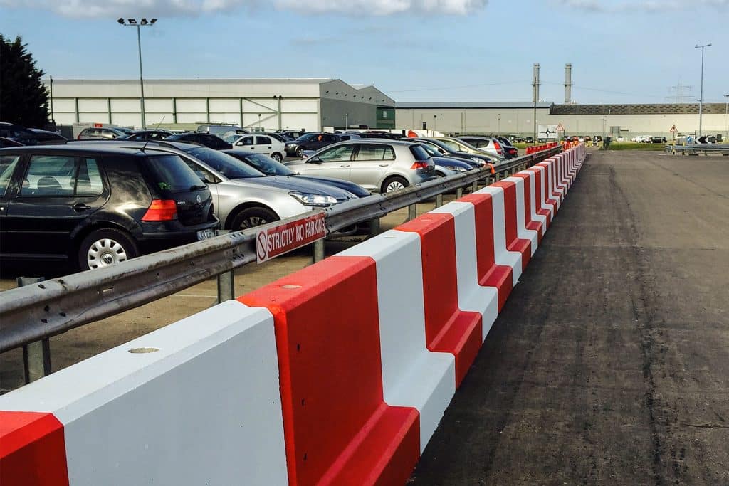 Painted concrete barriers next to a car park.